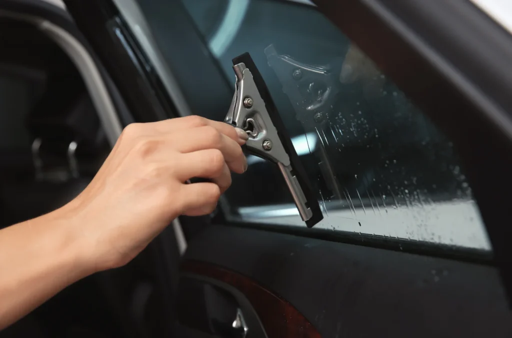 Female worker tinting car window